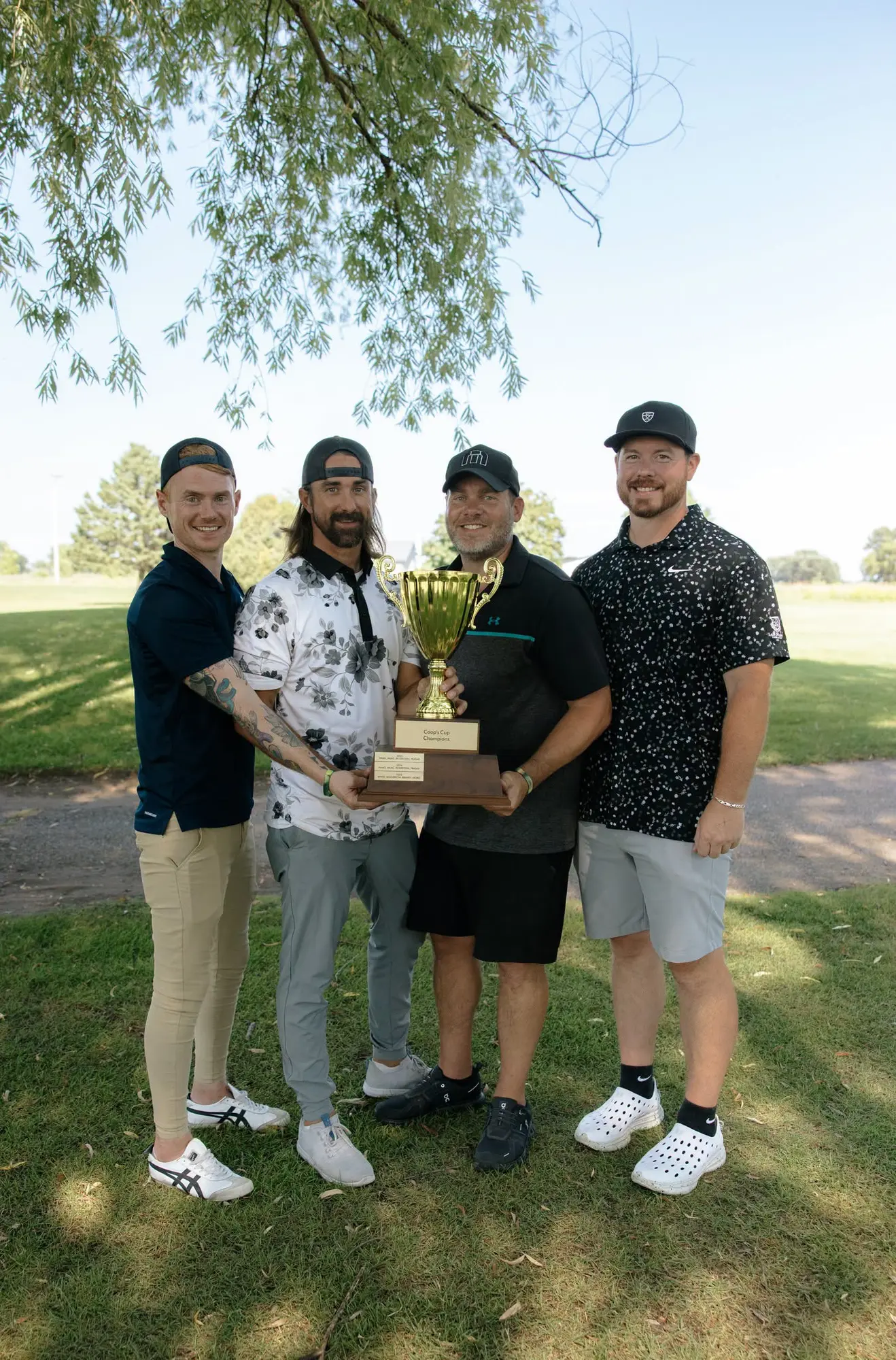 Kerby, Kelby, Carson, and Danny holding the 2026 Coop's Cup trophy