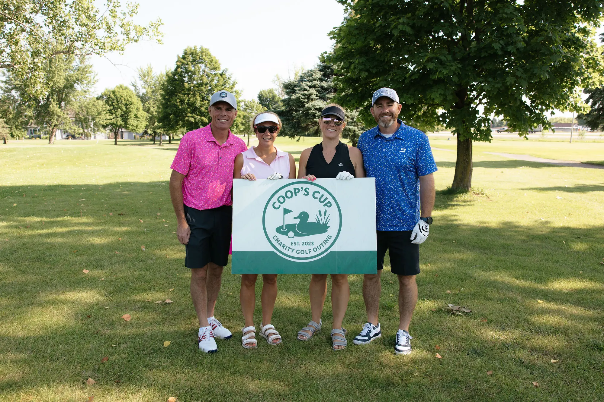 A team poses with the Coop's Cup banner