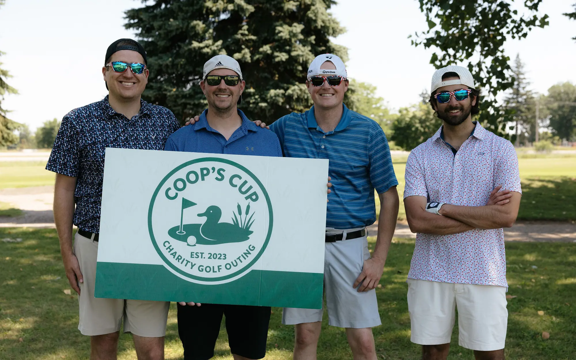 Four golfers in blue pose on the course