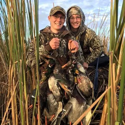 Dakota and a friend holding ducks after a hunt